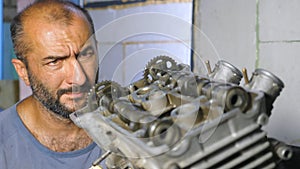 Portrait of professional mechanic repairing motor of vehicle. Attentive repairer fixing automobile engine. Auto master