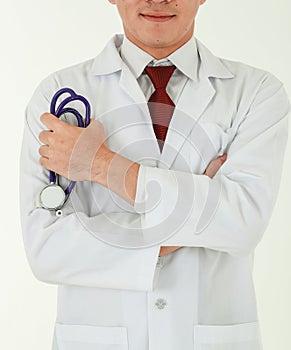 Portrait of a professional medical male doctor standing on white background with crossed arms, wearing white gown coat, and