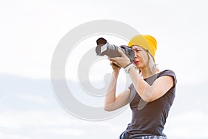 Portrait of a professional photographer in the open air. A girl photographer takes pictures of her camera on her camera