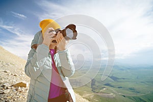 Portrait of a professional photographer in the open air. A girl photographer takes pictures of her camera on her camera