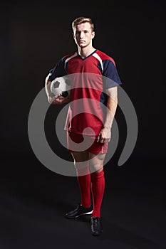 Portrait Of Professional Soccer Player With Ball In Studio