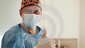 Portrait of the Professional Surgeon Looking Into Camera and Smiling after Successful Operation. In the Background