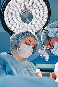 Portrait of professional surgeons during surgery on a blue background. Concept surgery, medicine. Surgeons are working