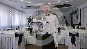 Portrait of a professional waiter with a tray in his hands in a restaurant.