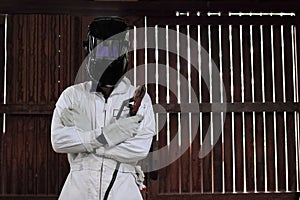 Portrait of professional welder with torch and protective helmet in white uniform in the factory. Industrial concept.