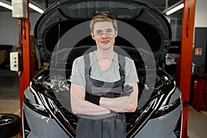 Portrait of professional young male car mechanic in overalls