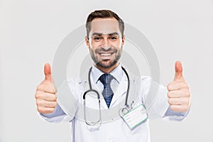 Portrait of professional young medical doctor with stethoscope smiling at camera and showing thumbs up