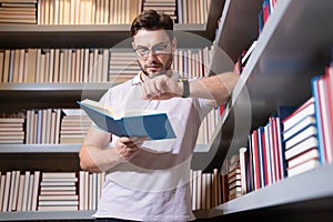 Portrait of professor with book in classroom. Handsome professor in library. Teachers Day. Good professor. Man professor