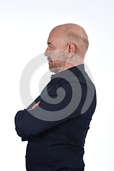 Portrait of profile of  a bald man on white, arms crossed photo