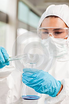 Portrait of a protected scientist pouring liquid