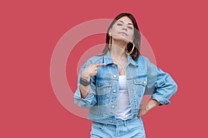 Portrait of proud beautiful brunette young woman with makeup in denim casual style standing, pointing herself and looking at