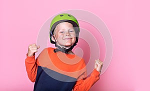 Portrait of proud blond kid in green helmet. happy and excited celebrating victory. School child expressing school boy