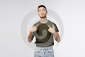 Portrait of proud and boastful young asian macho man, show-off his big ego, pointing at himself with pleased bragging