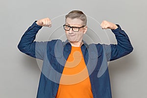 Portrait of proud and rebellious mature man raising clenched fists up