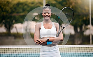 Portrait of a proud tennis player on the court. Young tennis player arms crossed standing on the court. Happy player