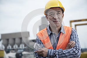 Portrait of proud worker with arms crossed in protective workwear outside of a factory photo