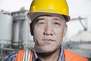 Portrait of proud worker in protective workwear outside of a factory