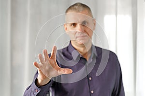 Portrait of a psychosomatic psychologist making a hand gesture to attract attention
