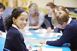 Portrait Of Pupil In Classroom With Teacher