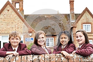 Portrait Of Pupils In Uniform Outside School Building photo