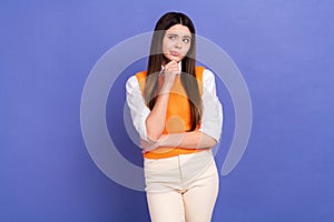 Portrait of puzzled confused minded cute girl wear stylish shirt orange vest look at empty space isolated on violet