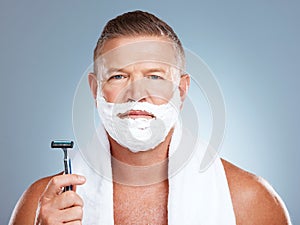 Portrait, razor and old man shaving in studio with foam, skincare or beauty on grey background. Face, blade and mature