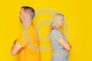Portrait of a real Caucasian couple in their 40s having an argument, they are angry and turn their backs on each other