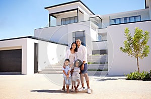 Portrait, real estate and happy family moving into their new luxury home, house or property in summer. Happy parents and