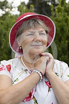 Portrait Real Happy Smiling Senior Woman In Hat. Green Trees, Park on Background. Pleased