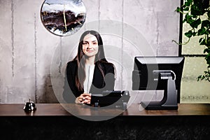 Portrait of receptionist at desk in lobby. Banner design. Friendly concierge at hotel reception behind the counter