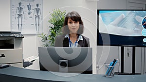 Portrait of receptionist working at hospital reception desk