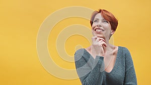 Portrait of red hair woman in her 40s  on yellow background.