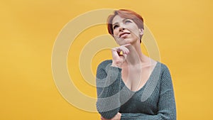 Portrait of red hair woman in her 40s  on yellow background.