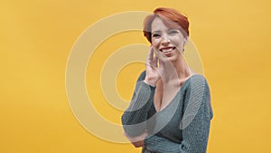 Portrait of red hair woman in her 40s  on yellow background.