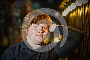 Portrait of red-haired freckled serious teenage boy