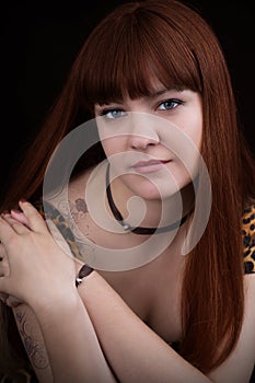 Portrait of red-haired girl with tattoo