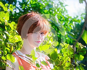 Portrait of a red-haired happy woman in park