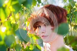 Portrait of a red-haired happy woman in park