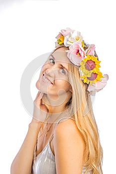 Portrait of a red-haired woman with a beautiful wreath of flowers on her head, throwing her head back slightly smiling