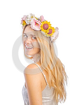 Portrait of a red-haired woman with a beautiful wreath of flowers on her head, turning over her shoulder, smiling