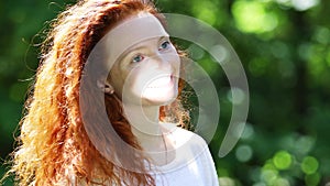 Portrait of a red-haired  woman with a sunny spot on her face