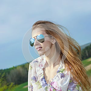 Portrait of red long-haired beautiful girl in  sunglasses