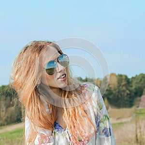 Portrait of red long-haired beautiful girl in  sunglasses