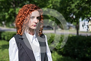 Portrait of redhead business woman with serious mood outdoor.