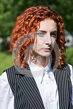 Portrait of redhead business woman with serious mood outdoor.