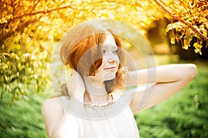 Portrait of redhead girl with blue eyes on nature