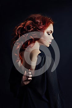 Portrait of redhead woman with long hair on black background. Perfect girl with the blue eyes, nice clean skin