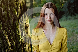 Portrait Of Redhead Young Woman Standing Near Tree