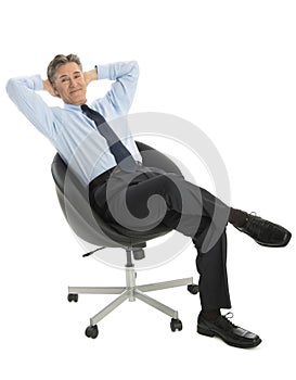 Portrait Of Relaxed Businessman Sitting On Office Chair
