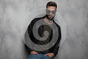 Portrait of relaxed man wearing leather jacket and sunglasses smiling